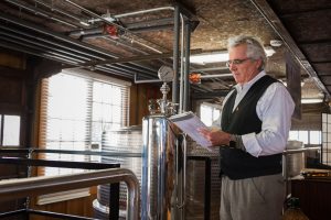 Man taking notes in front Wine Filtration System